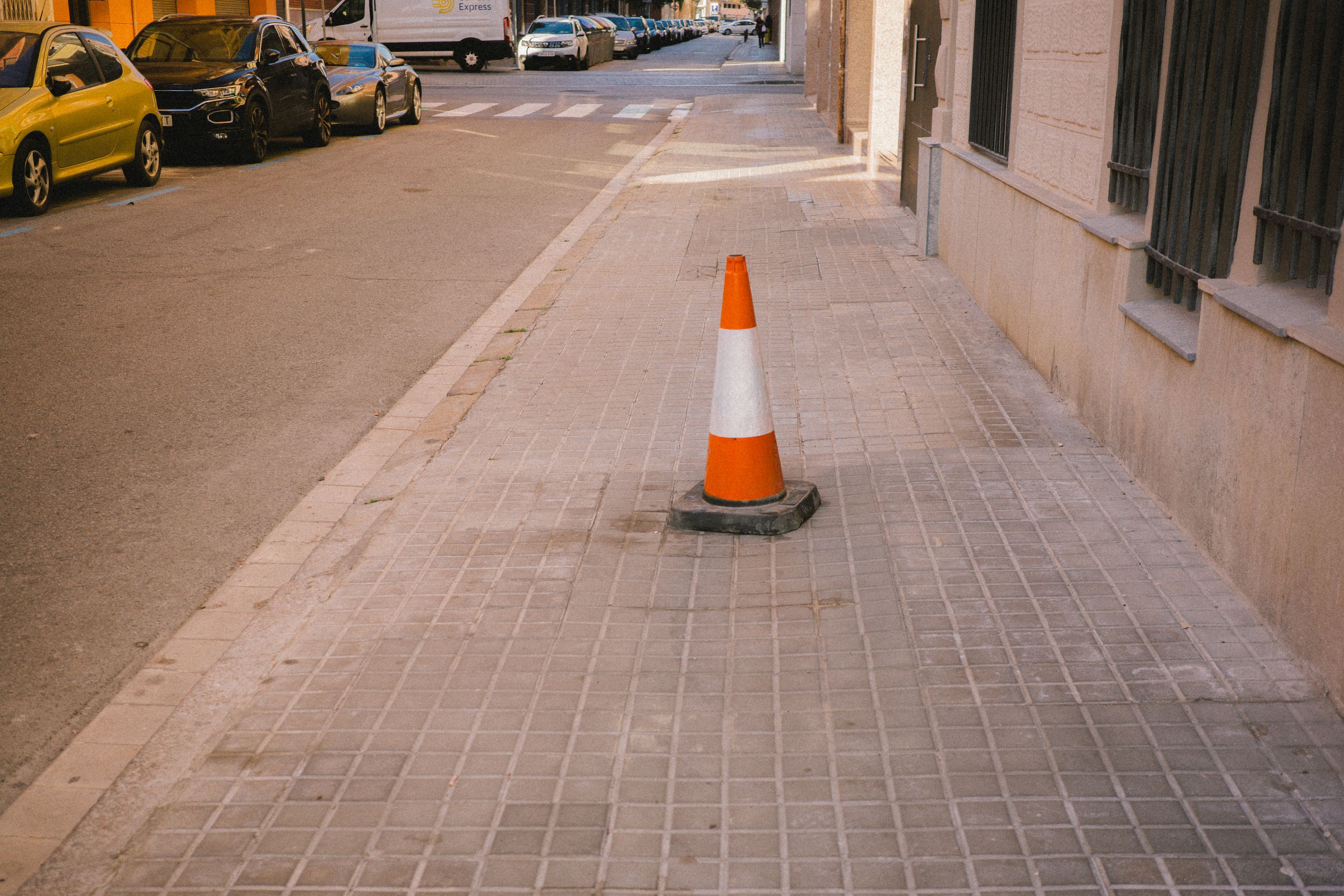 Foto de un cono en el centro de la acera.