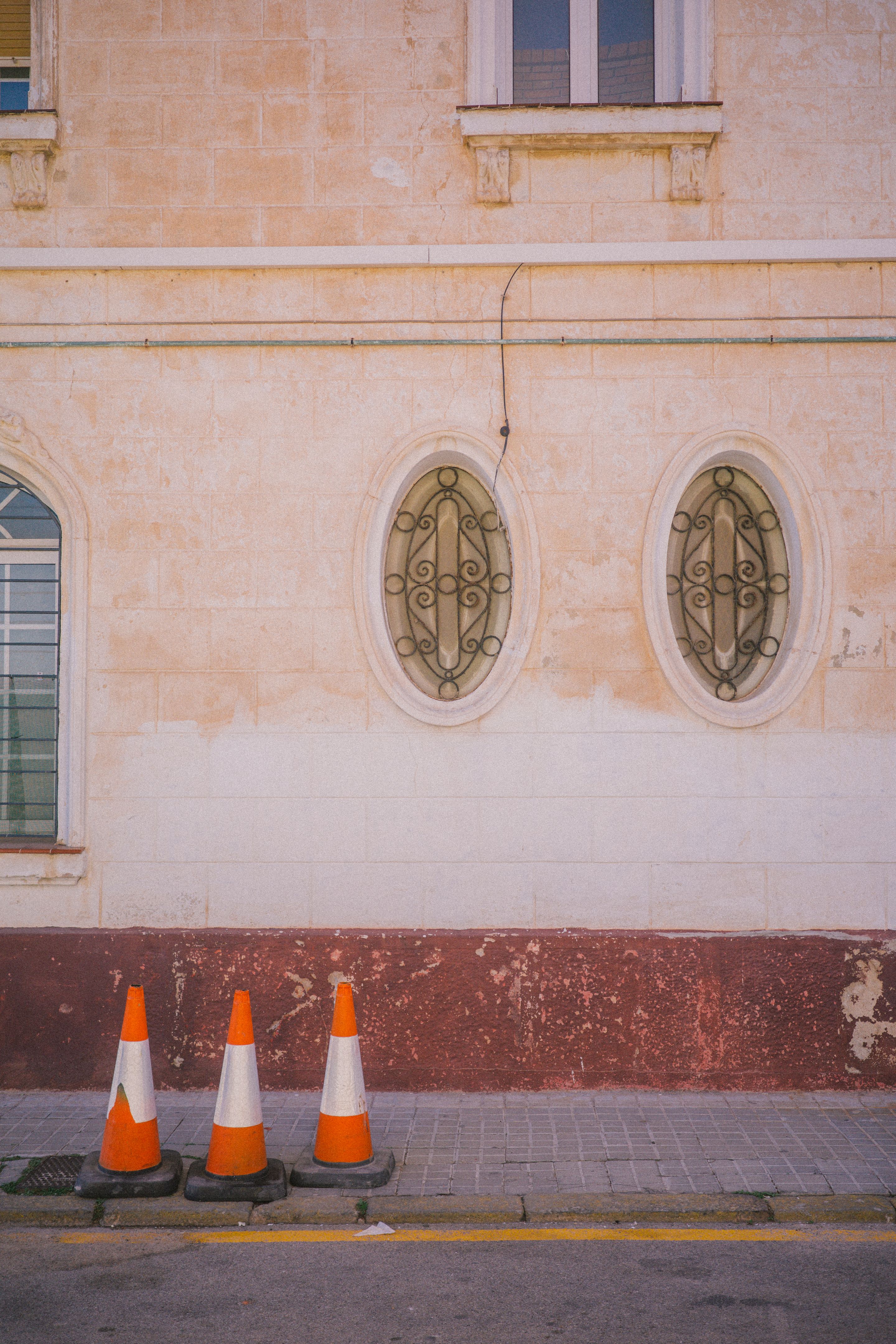 Foto de tres conos frente al muro de un edificio.